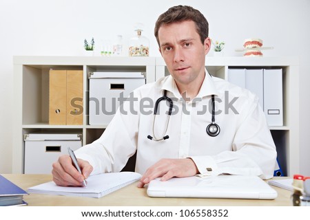 Doctor taking notes in office during a consulation