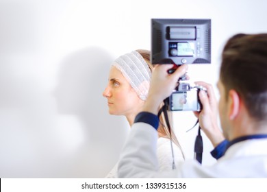 Doctor Taking Picture Of Young Female Patient Before Aesthetic Treatment On White Background.