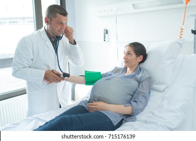 Doctor Taking Pregnant Woman's Blood Pressure