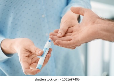 Doctor taking sample of diabetic patient's blood using lancet pen, closeup - Shutterstock ID 1031697406