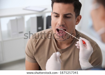 Doctor taking sample for DNA test from man in clinic