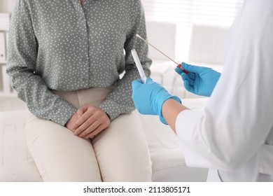 Doctor Taking Sample For STD Testing From Woman In Clinic, Closeup