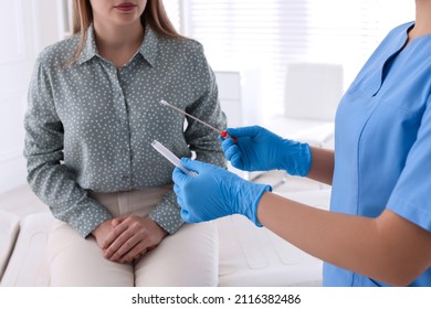 Doctor Taking Sample For STD Testing From Woman In Clinic, Closeup