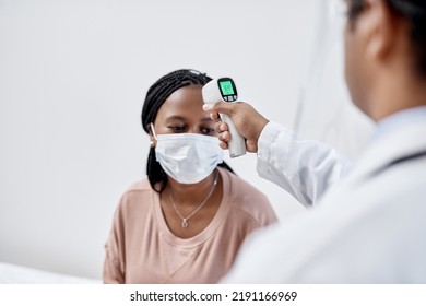 Doctor Taking Temperature Of A Covid Patient While Testing For High Fever Symptoms Of Sick, Flu Or Illness. Screening Woman For A Healthcare Consult, Checkup And Visit In A Hospital Or Medical