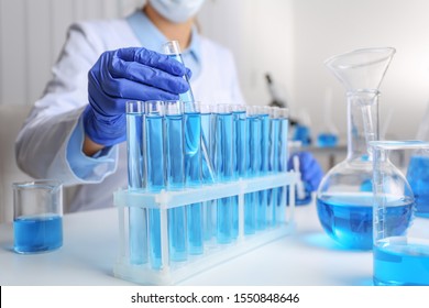Doctor taking test tube with blue liquid, closeup. Laboratory analysis