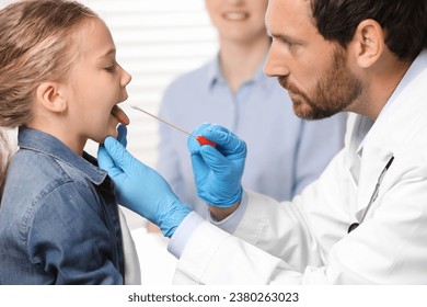 Doctor taking throat swab sample from girl`s oral cavity indoors - Powered by Shutterstock