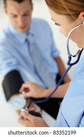 Doctor Taking Young Man's Blood Pressure