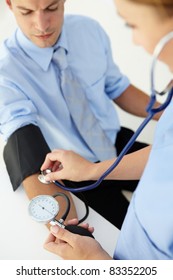 Doctor Taking Young Man's Blood Pressure