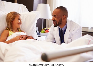 Doctor Talking To Child Patient In Hospital Bed