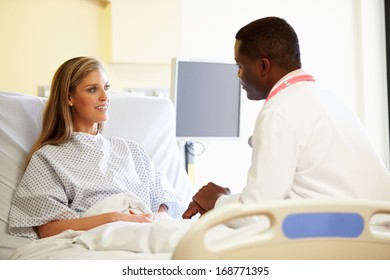 Doctor Talking To Female Patient In Hospital Room