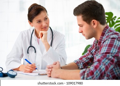 Doctor Talking To Her Male Patient At Office