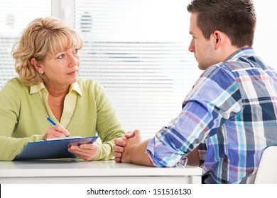 Doctor Talking To Her Male Patient At Office