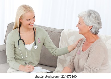 Doctor Talking With Her Patient Wearing Breast Cancer Awareness Ribbon