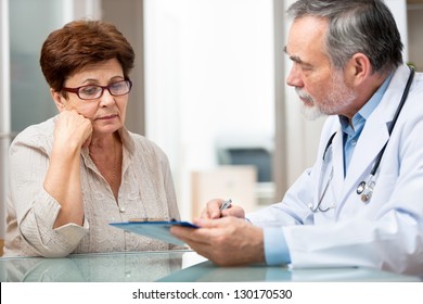 Doctor Talking To His Female Patient At Office