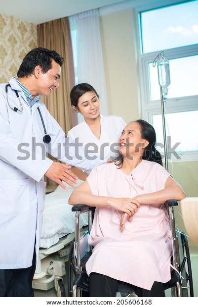 Doctor Talking To His Female Patient In A Wheelchair