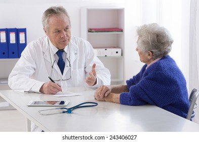 Doctor talking to his female senior patient at the office