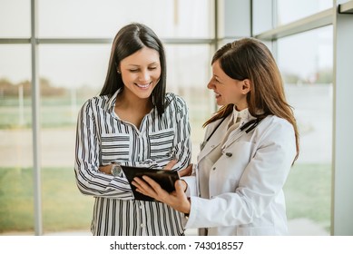 Doctor Talking And Laughing With Her Female Patient.