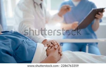 doctor talking with man patient for monitoring and check up after surgery. doctor touching patient hand and consoling.