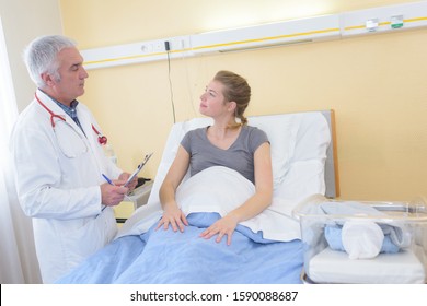 Doctor Talking To New Mother On A Maternity Ward