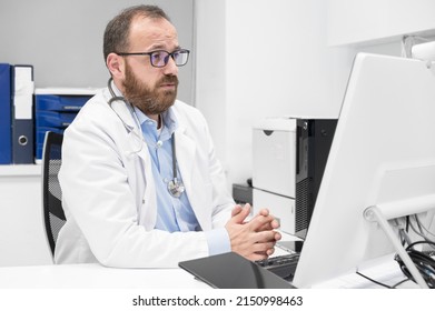 Doctor Talking To Online Patient On Desktop Computer Screen Sitting At Clinic Office Desk Giving Online Consultation For Domestic Health Treatment. Telemedicine Remote Medical Appointment. 