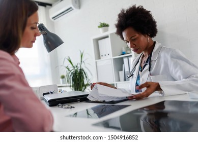 Doctor Talking With Patient At Desk In Medical Office. Health Care Concept, Medical Insurance. Womens Health.