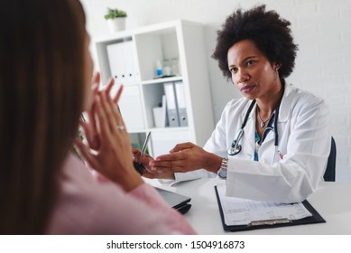 Doctor Talking With Patient At Desk In Medical Office. Health Care Concept, Medical Insurance. Womens Health.