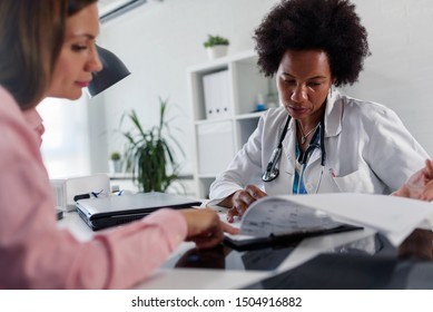 Doctor Talking With Patient At Desk In Medical Office. Health Care Concept, Medical Insurance. Womens Health.