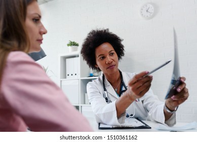 Doctor Talking With Patient At Desk In Medical Office. Health Care Concept, Medical Insurance. Womens Health.