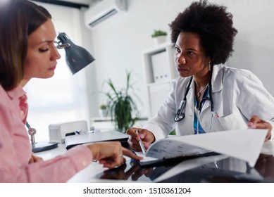 Doctor Talking With Patient At Desk In Medical Office. Health Care Concept, Medical Insurance. Womens Health.