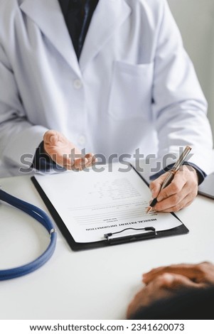 Doctor talking to patient and filling patient history, examination, treatment, medical and health concept.	