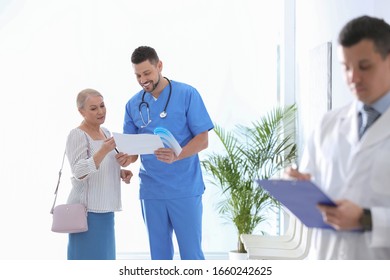 Doctor Talking With Patient In Hospital Hall