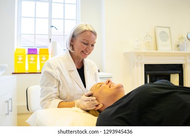 Doctor Talking To Patient Lying Down On Hospital Bed.