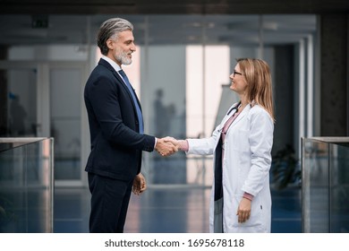 Doctor Talking To Pharmaceutical Sales Representative, Shaking Hands.