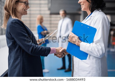 Doctor talking to pharmaceutical sales representative, shaking hands.