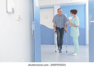 doctor talking to recovering mid age man with crutches - Powered by Shutterstock