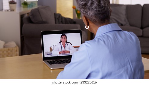 Doctor talking to Senior African woman patient over webcam - Powered by Shutterstock