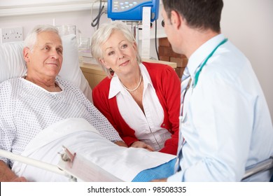 Doctor talking to senior couple on UK Hospital ward - Powered by Shutterstock