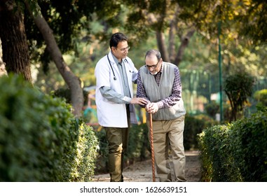 Doctor talking with senior man in hospital garden - Powered by Shutterstock