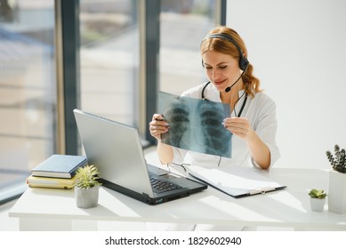 Doctor Talking With Sick Person Through Laptop Online System And Using Mobile Digital Tablet Computer Searching Patient Medical Records On The Database Files Document.