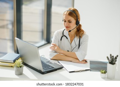 Doctor Talking With Sick Person Through Laptop Online System And Using Mobile Digital Tablet Computer Searching Patient Medical Records On The Database Files Document.