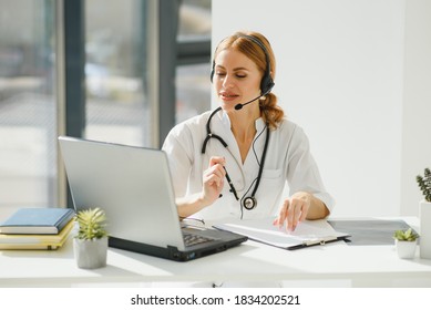 Doctor Talking With Sick Person Through Laptop Online System And Using Mobile Digital Tablet Computer Searching Patient Medical Records On The Database Files Document.