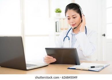 Doctor Talking With Sick Person Through Laptop Online System And Using Mobile Digital Tablet Computer Searching Patient Medical Records On The Database Files Document.