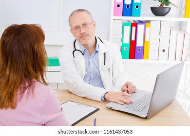 Doctor Is Talking With Woman Patient And Sitting In Medical Office.Man In White Uniform. Medical Insurance. Copy Space. Quality Medicine Concept.