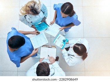 Doctor, team and documents in collaboration above in healthcare planning, meeting or brainstorming at hospital. Group of medical professionals with paperwork in teamwork, strategy or ideas at clinic - Powered by Shutterstock