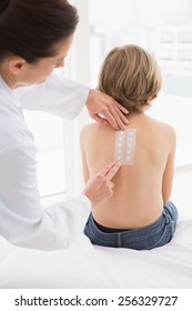 Doctor Testing A Childs Skin In Her Office