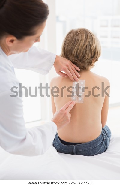 Doctor testing a\
childs skin in her\
office