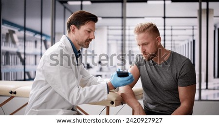 Doctor Testing Glucose Level With Continuous Glucose Monitor