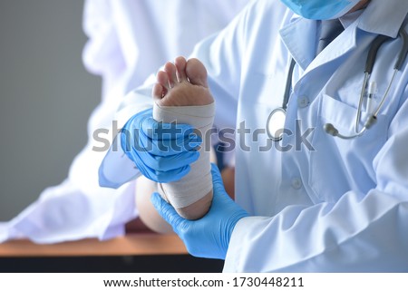 The doctor is treating the heel Podiatrist treating feet during procedure