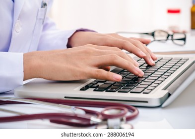 Doctor Typing Information On The Computer In Office
