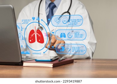 A doctor in uniform reads a lung examination report on a laptop virtual display while sitting in a hospital. World No Tobacco Day, lung cancer, pulmonary hypertension, and pneumonia